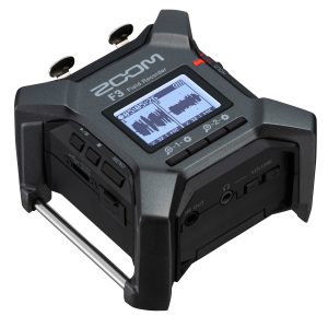 Zoom F3 field recorder with dual XLR inputs shown on a recording setup outdoors.